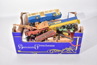 une boîte remplie de petites voitures et de camions posée sur une surface blanche