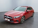 une Mercedes CLA rouge garée dans une pièce blanche