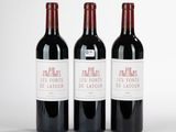 trois bouteilles de vin rouge posées côte à côte sur une table