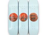 trois skateboards sur lesquels sont posés des ballons de basket, alignés les uns à côté des autres