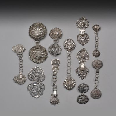 Plusieurs bijoux en argent sont exposés sur un fond blanc