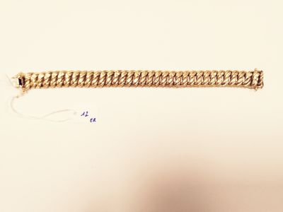 a close up of a gold bracelet on a white surface