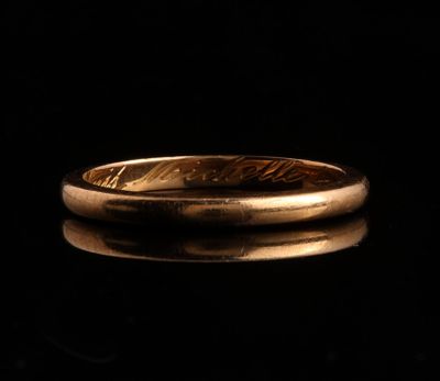 gros plan d'une bague en or sur une surface noire
