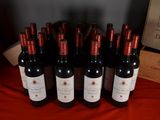 several bottles of red wine are lined up on a table