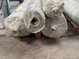 several rolls of plastic sitting on top of a pallet in a warehouse