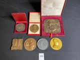 some gold and silver coins are in a red box on a table
