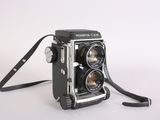 a black and white photo of a camera on a white surface