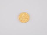 a close up of a gold coin on a white surface