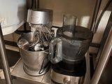 a metal shelf with a blender, mixer, and other kitchen items on it