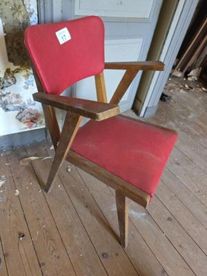 une chaise rouge qui se trouve au milieu d'une pièce
