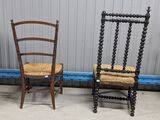pair of antique wooden chairs with rope seats against a wall