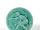 an image of a green ceramic button with a woman on a horse