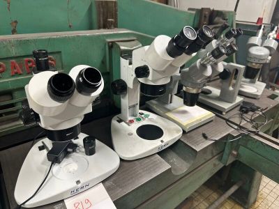 trois microscopes posés sur une table