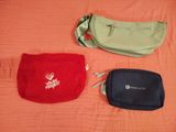 two bags are sitting on a bed next to each other