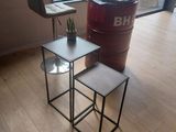 two tables and a chair in the corner of a room