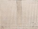 an antique white wicker bench with a wooden seat and foot rest