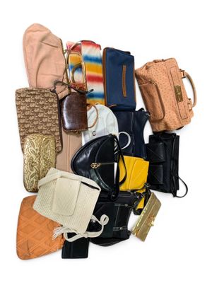 une pile de sacs à main et de sacs à bandoulière posée sur une surface blanche