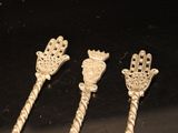 three silver spoons sitting on top of a table next to each other