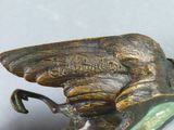 an image of a bronze statue of a bird with wings on it