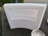 a white toilet sitting on the ground next to a trash can
