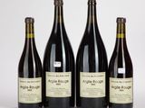 quatre bouteilles de vin sont alignées sur une table