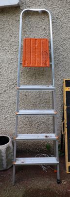 a ladder leaning against a wall next to a chalk board