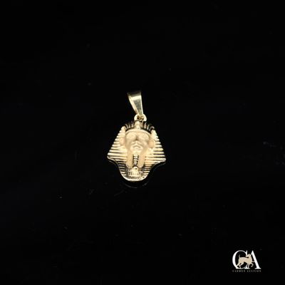 un pendentif représentant un masque égyptien doré sur fond noir
