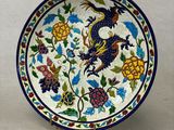 une image représentant une assiette décorative ornée d'un oiseau et de fleurs
