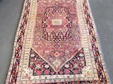 Un tapis persan ancien est exposé dans une boutique
