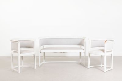 deux chaises blanches et une table dans une pièce aux murs blancs