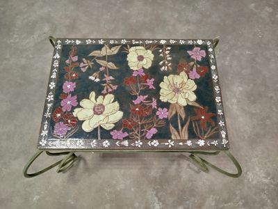 a tray with flowers painted on it on the floor