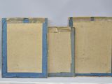 three pieces of cardboard with blue trims are sitting on a shelf