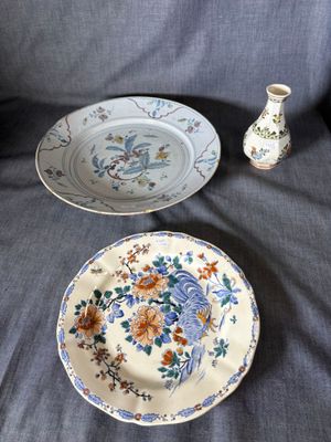 two plates and a vase sitting on a couch