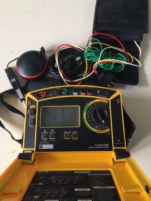 un ordinateur portable avec un boîtier jaune et des câbles posés sur la table