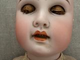 a close up of a doll ' s face on a gray background