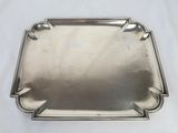 a silver tray on a white table with a white background