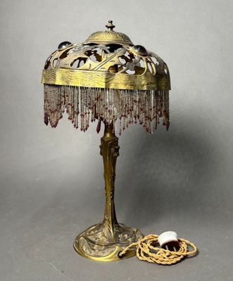 une lampe posée sur une table et ornée de perles