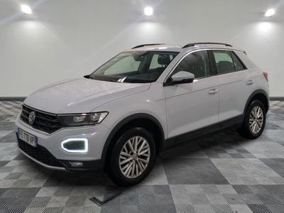 a white volkswagen suv is parked in a room with a checkered floor