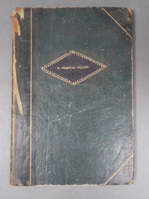 an old book sitting on top of a table on a gray surface