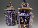 pair of blue and gold vases with floral designs on them
