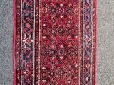 a red rug on the wall next to a window