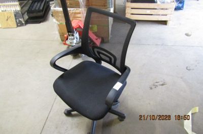 une chaise de bureau noire avec une assise noire, dans un entrepôt