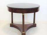 une table ronde avec un plateau noir et un piètement en bois
