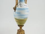 a blue and white vase sitting on a gold stand