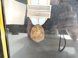 reflet d'une personne en train de prendre en photo une médaille dans la vitre d'une voiture