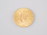 a close up of a gold coin on a white surface
