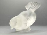 a glass bird that is sitting on top of a table