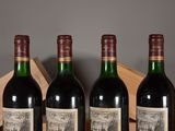 three bottles of red wine sit in a wooden crate