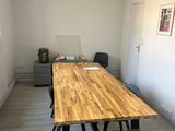 une table et des chaises en bois dans une pièce aux murs blancs