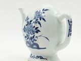 a blue and white teapot on a white surface